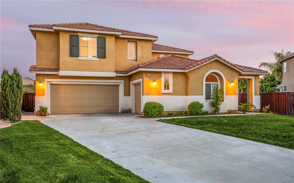 Twilight view of a Mediterranean style home in Temecula, California with a warm sunset sky